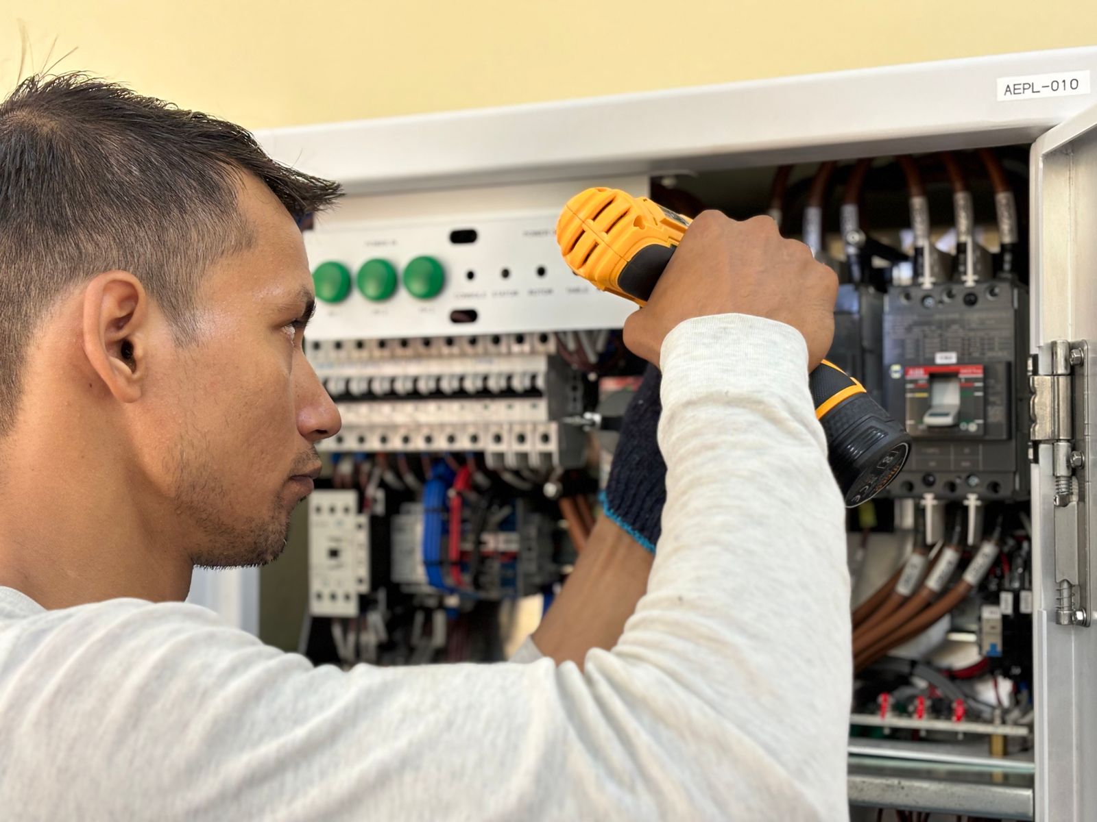 An electrician working in a breaker panel